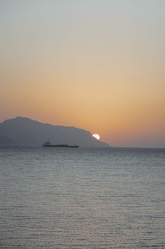 宁静的日落下，平静的海面上映着渡轮的轮廓，非常适合自然摄影