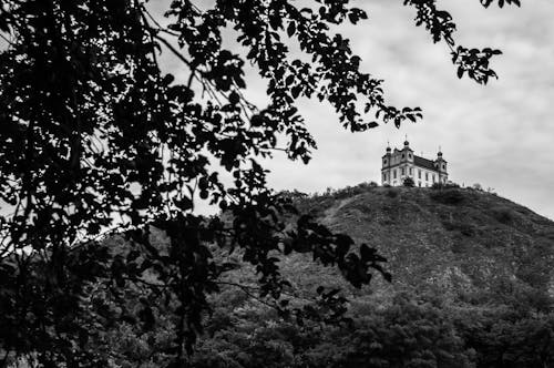 Grayscale Photo of Building on top of the Hill