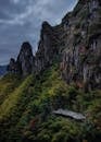 Steep Mountains Covered in Trees Under a Stormy Sky