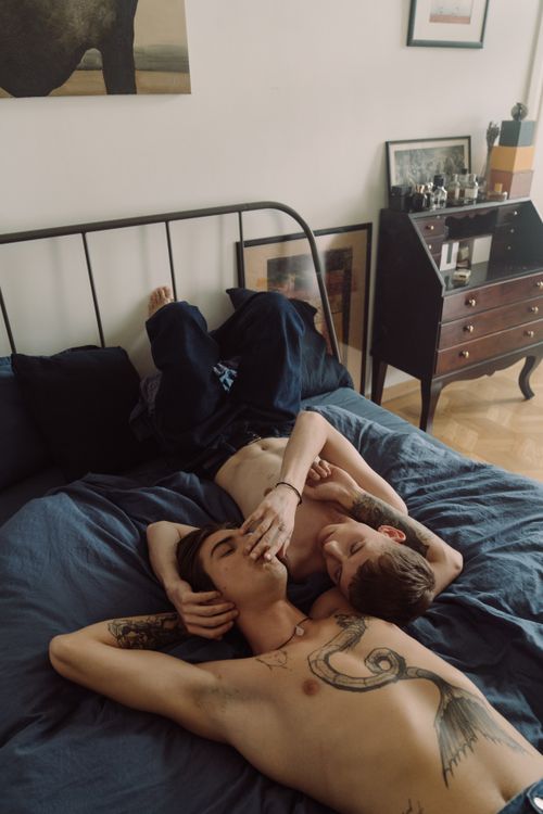 Free Two people relaxing intimately on a bed, showcasing body art and affection. Stock Photo
