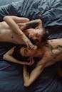Topless Man Lying on Bed Beside Woman
