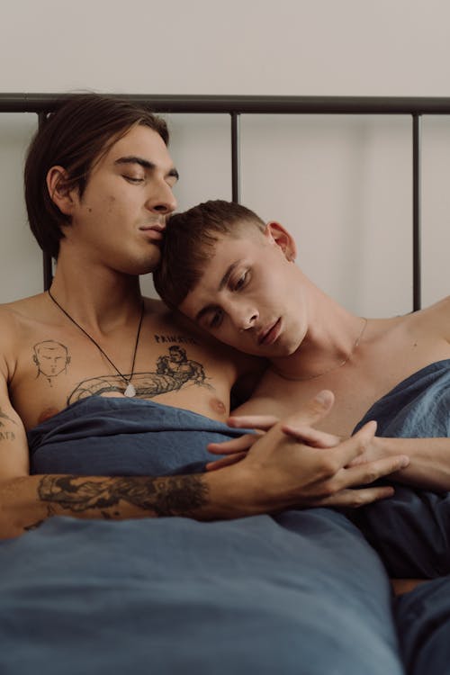 Free Gay Couple Lying Together in Bed  Stock Photo