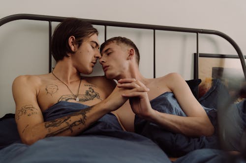 Free Gay Couple Lying Together in Bed  Stock Photo