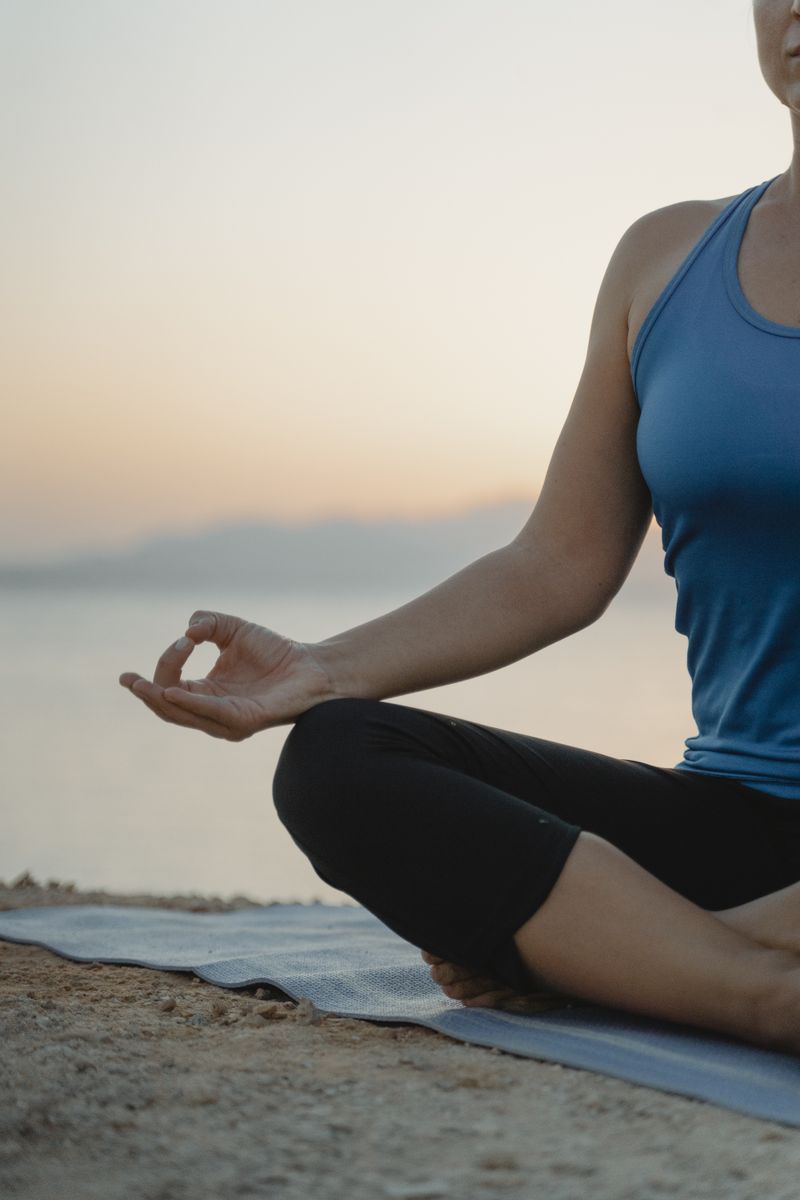 Woman practicing yoga on the beach