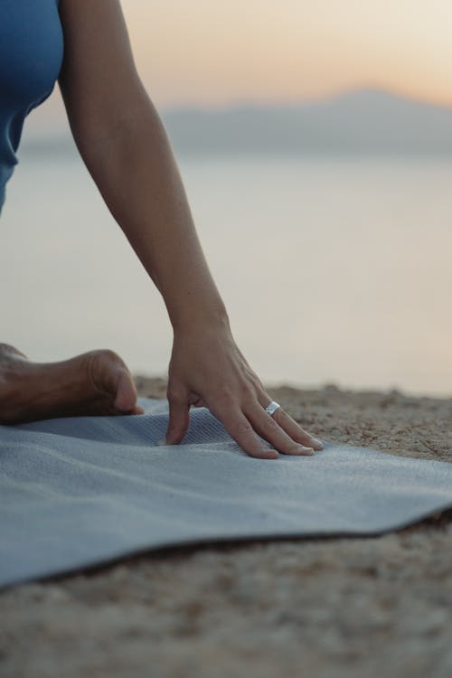 A Close-Up Shot of a Person on a Yoga Mat at the Beach