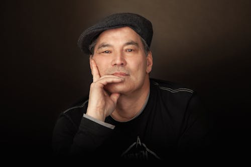 Man Wearing a Hat with Hand on Chin
