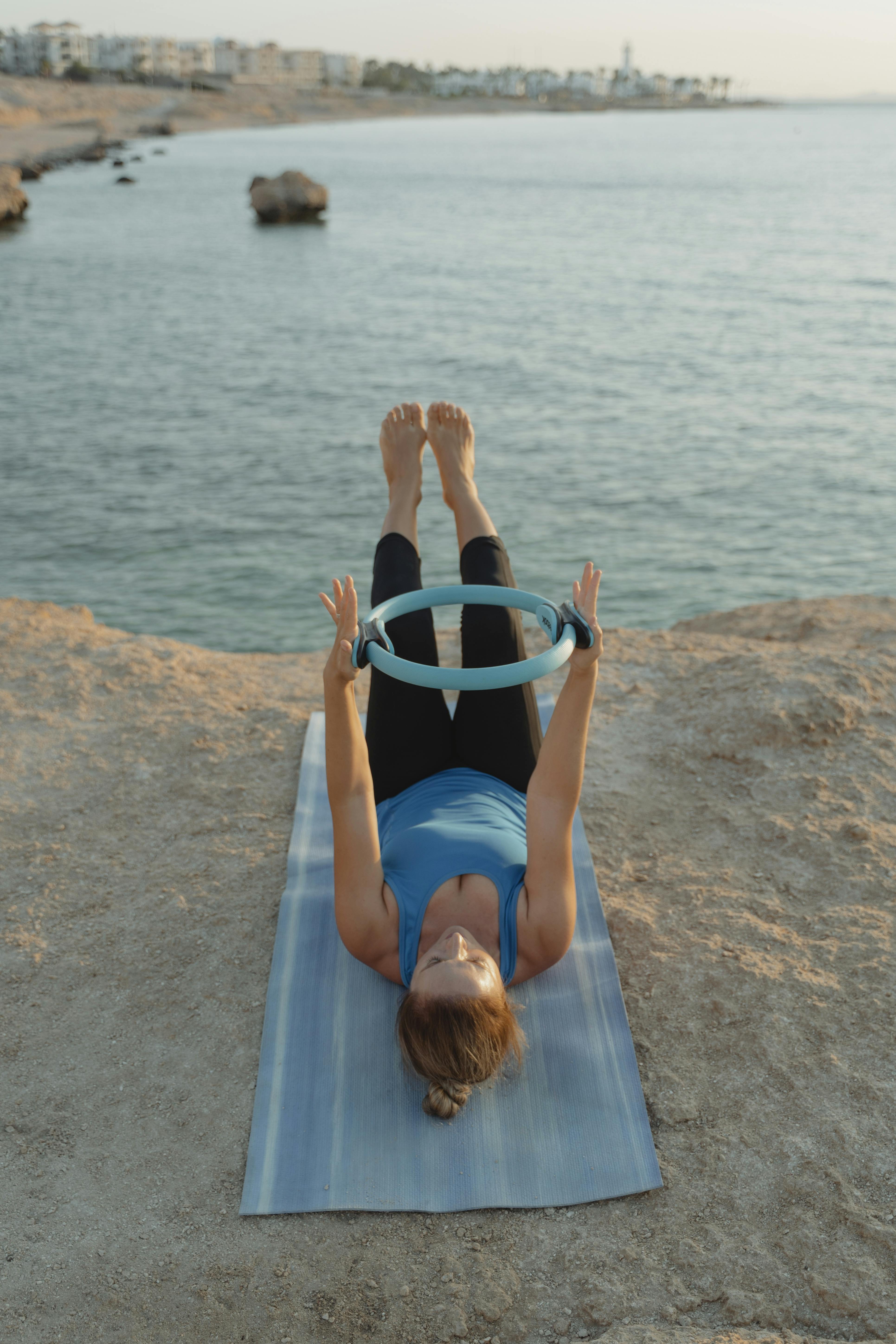 woman in blue tank top lying on brown wooden dock