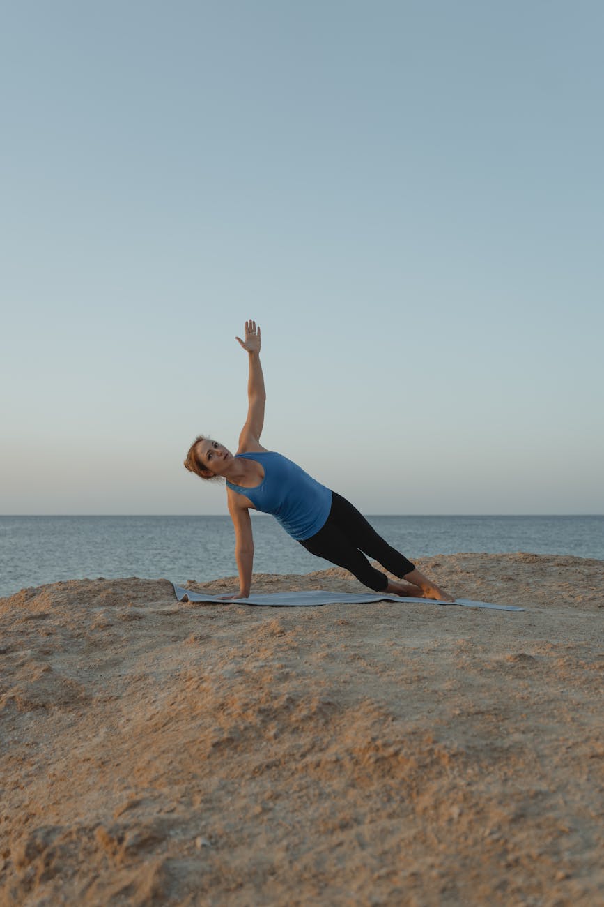 Woman in Blue Tank Top and Black Leggings Doing Yoga on Brown Rock ...