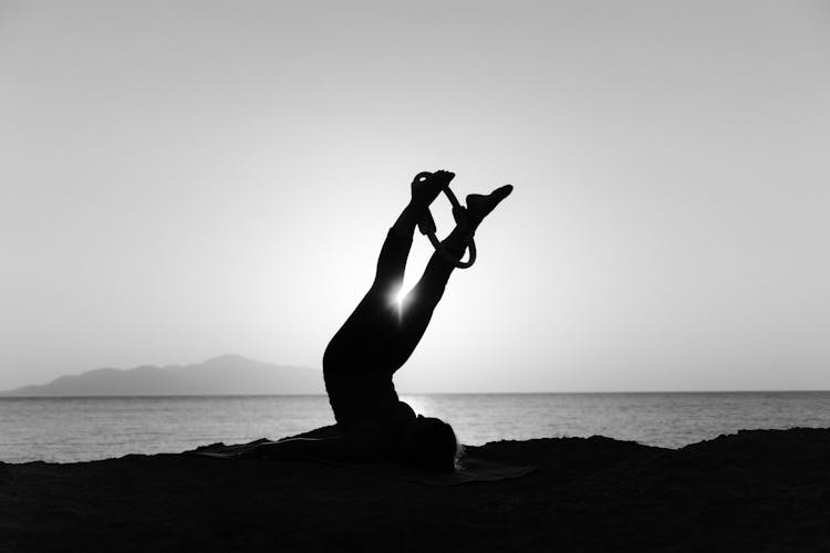 Silhouette Of A Person Doing Yoga Near The Ocean