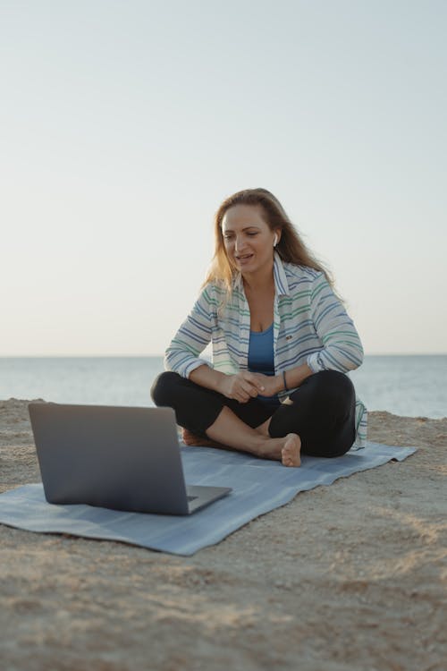 Woman Sitting on Yoga Mat Video Calling on Laptop 