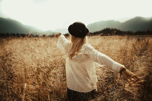 Free Woman Walking on Brown Grass Field Stock Photo