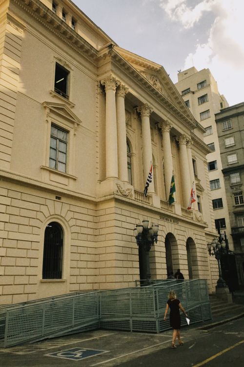 Free Elegant historic building with flags in a bustling city area, showcasing classical architecture. Stock Photo