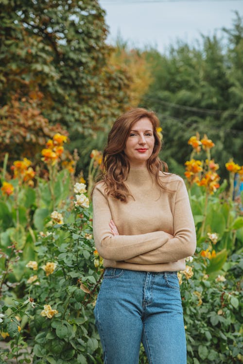 Adult woman standing in blooming garden