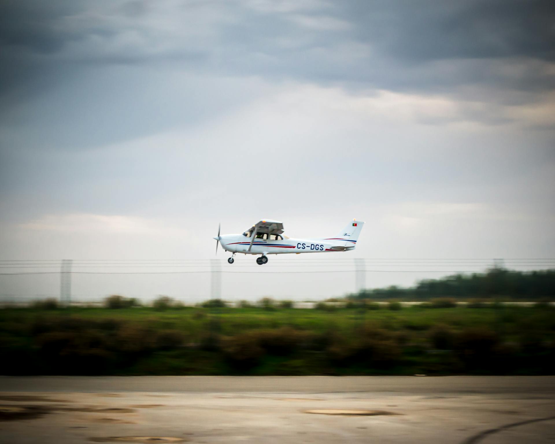 A small aircraft takes off from an aerodrome under a cloudy sky, showcasing aviation in action.