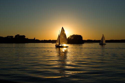 Sailboat on the Body of Water during Golden Houe