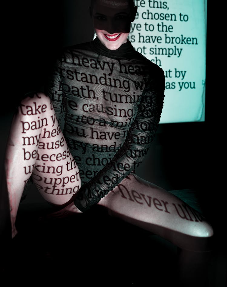 Abstract Photo Of Woman Sitting In Costume With Projected Text On Body