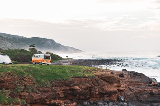Explore a serene coastal campsite with a classic VW van and a tent, perfect for adventure seekers.