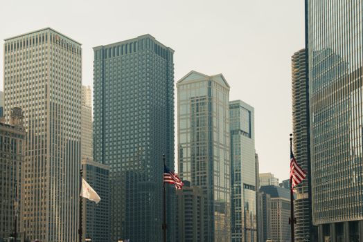 芝加哥的都市风景中，高耸的摩天大楼和美国国旗在前景格外醒目