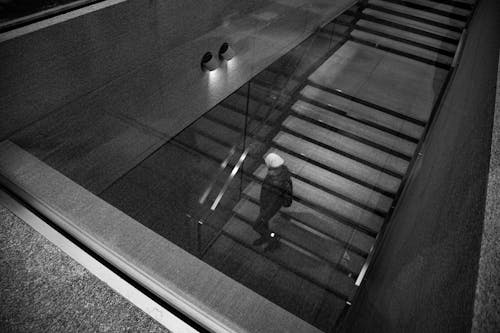 Unrecognizable person walking alone downstairs in building