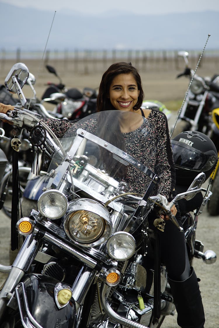 Woman In Gray And Black Floral Long Sleeve Shirt Sitting On A Motorcycle