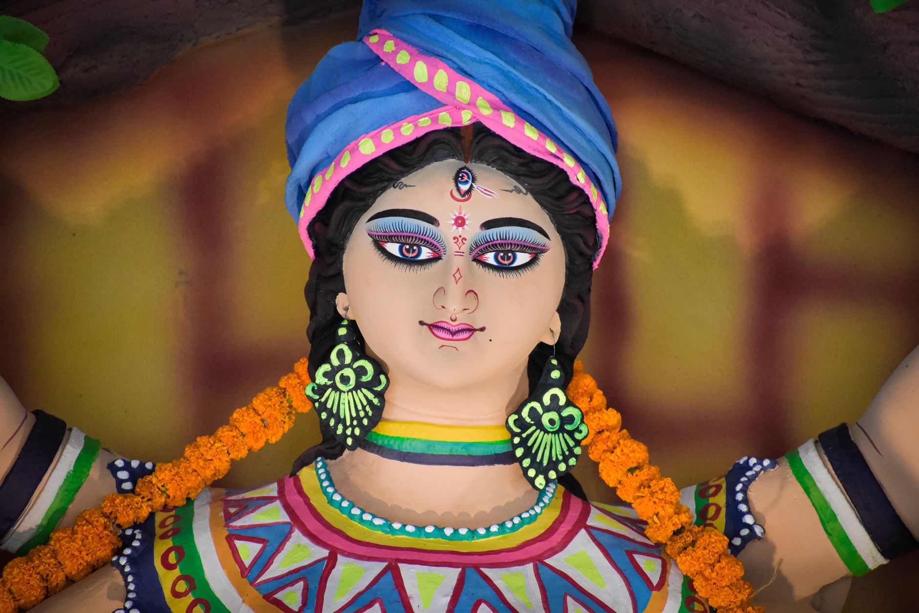 Vibrant close-up of a traditional Indian goddess statue adorned with flowers.