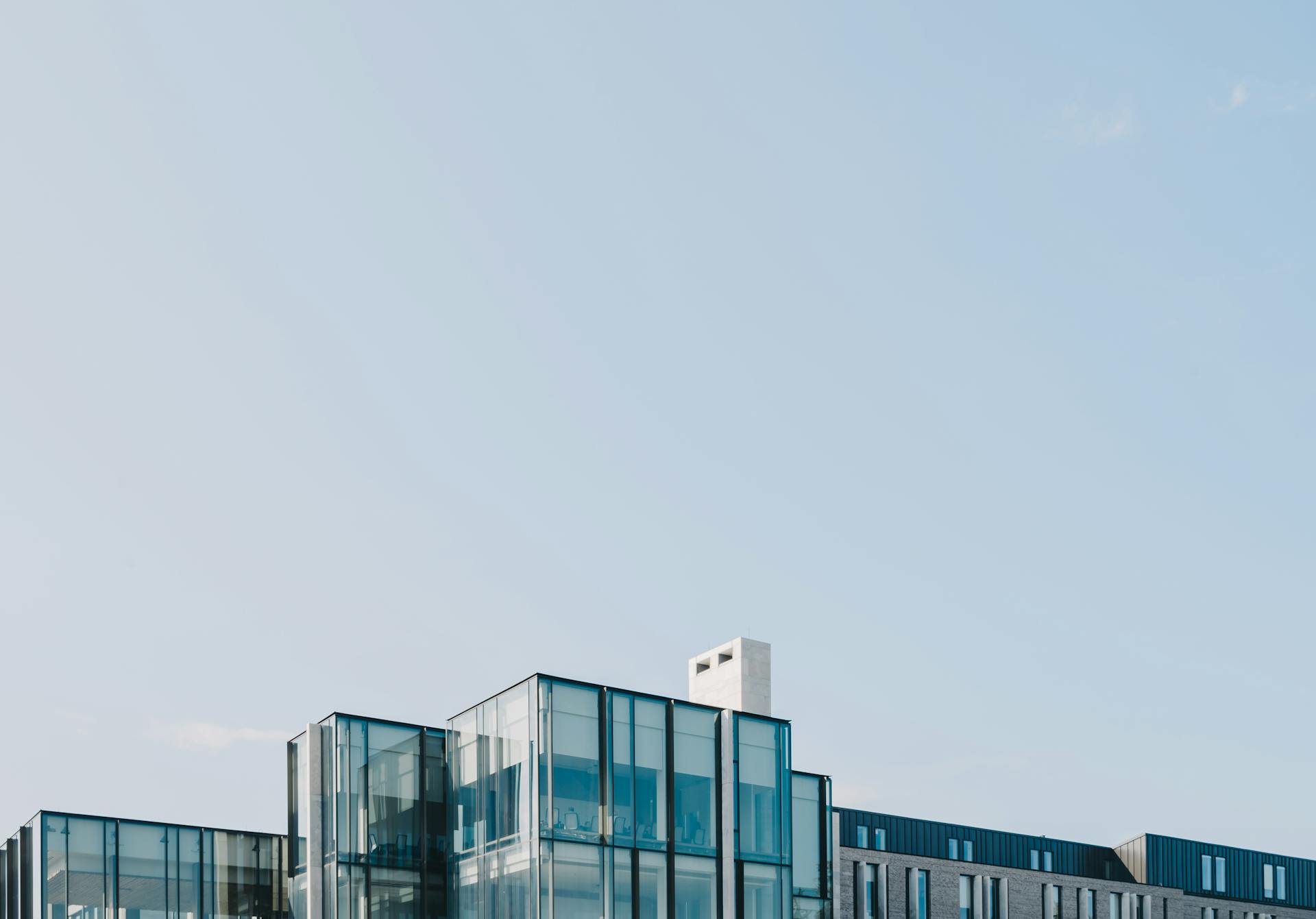 Contemporary glass structure in London, ON, showcasing modern architectural design against a clear sky.