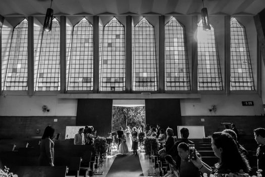 A striking black and white shot capturing a wedding ceremony inside a spacious church.
