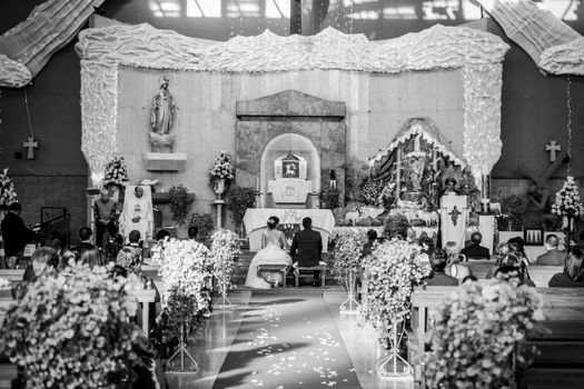 A classic black and white image capturing a wedding ceremony in a church.
