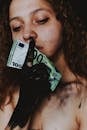 Crop young female with bare shoulders and dirty hand with dirty banknote near face