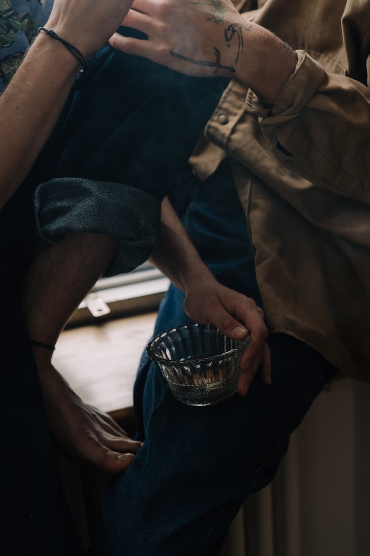 Person Holding A Glass Ashtray