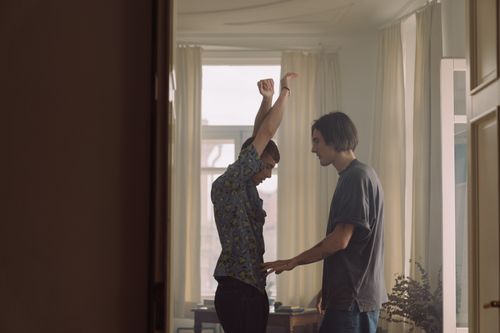 Free Two young men enjoying a joyful moment indoors with natural lighting. Stock Photo