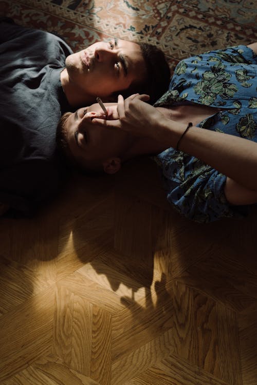 Men Lying on Floor in Opposite Directions
