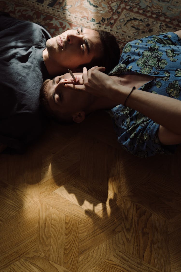 Men Lying On Floor In Opposite Directions
