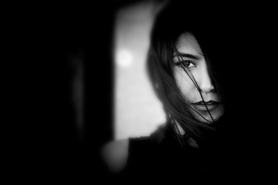 Artistic monochrome portrait capturing a woman's mysterious expression.