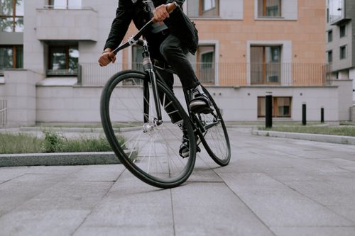 Free A fashionable cyclist performing a sharp turn on a city street, showcasing agility and style. Stock Photo