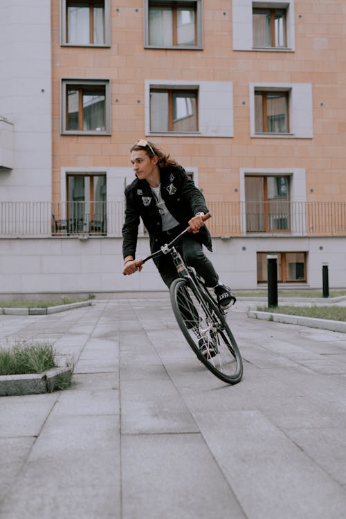黑夾克騎自行車在人行道上的女人