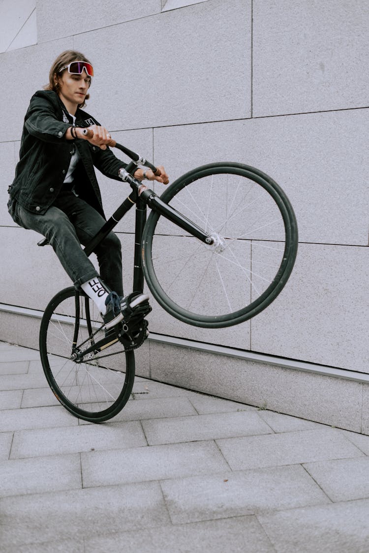 Man In Black Jacket Riding On Bicycle