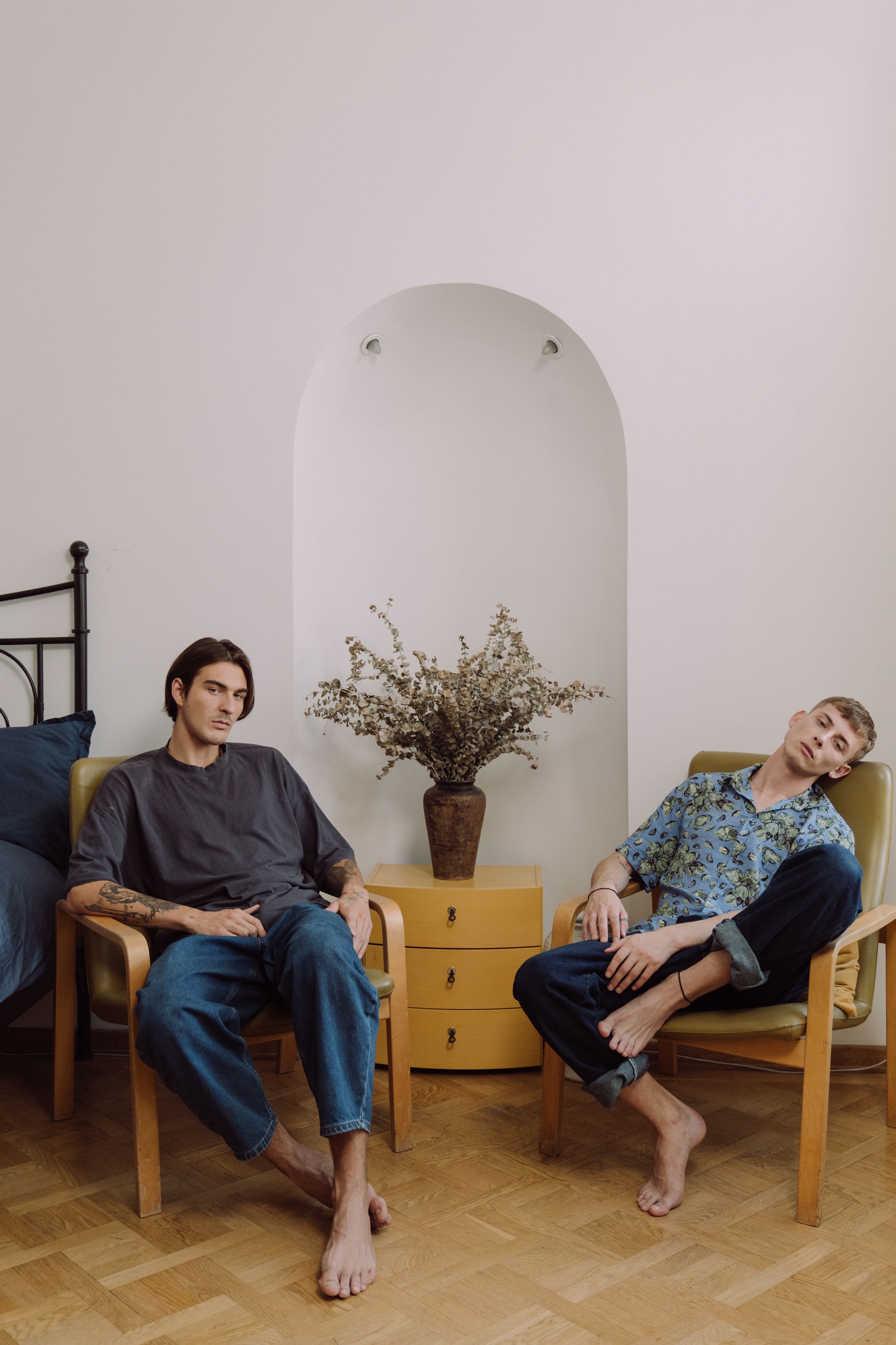 Two men sitting comfortably indoors, reflecting a calm and intimate connection.