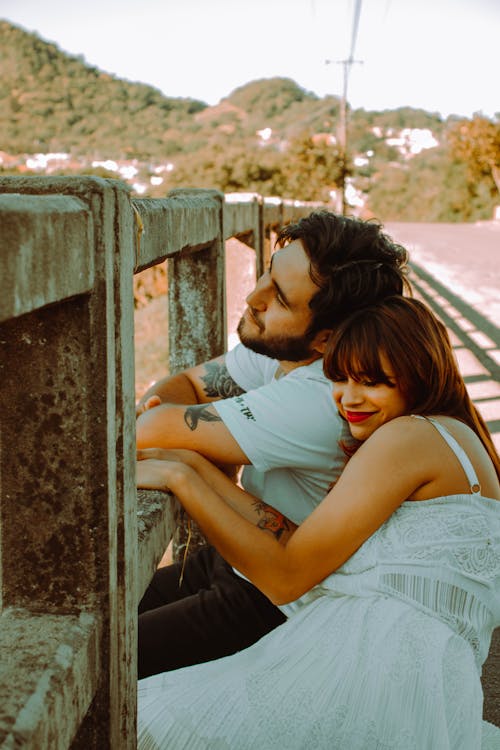 Woman Hugging Man by Barrier on Road