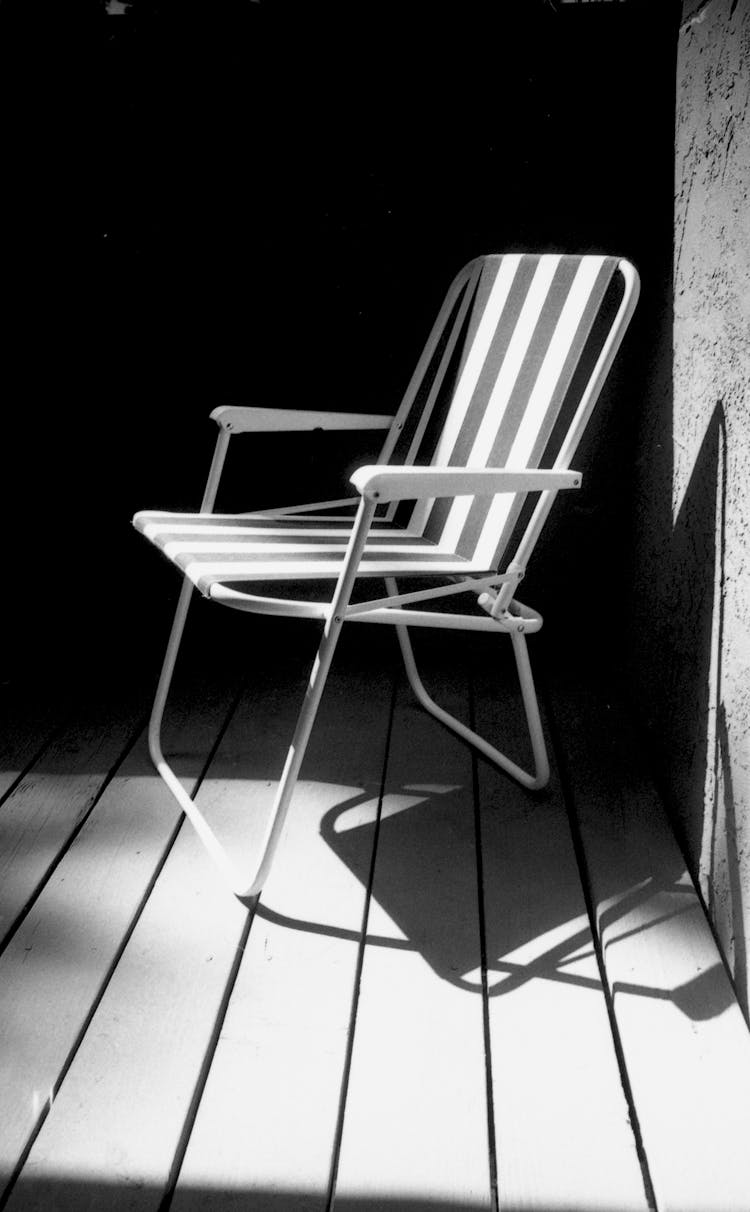 Black And White Photo Of Folding Chair On Sunny Patio