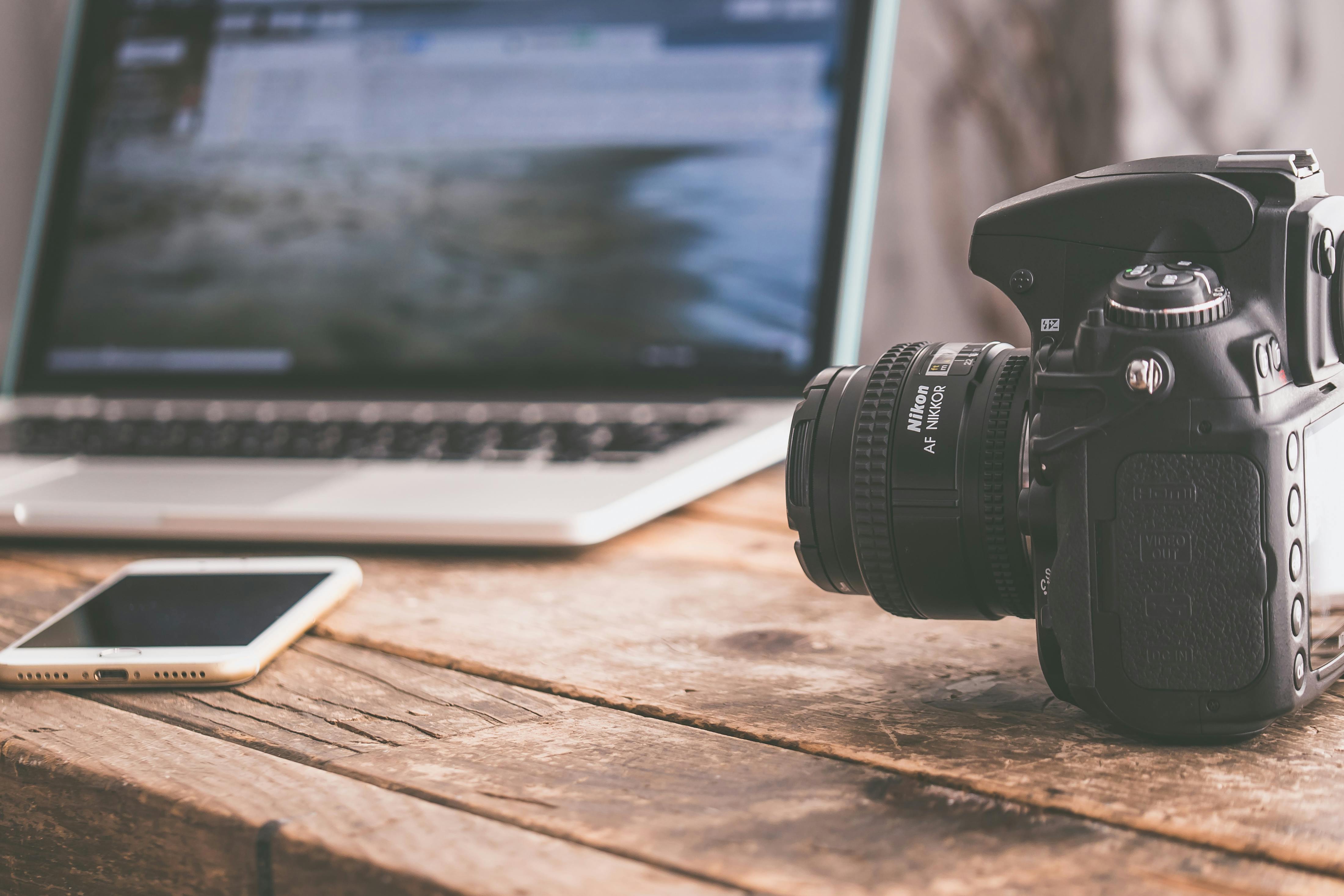 black dslr camera on beige wooden surface