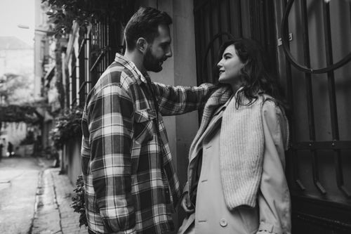 Free Stylish couple sharing a moment in an urban alley, captured in black and white. Stock Photo