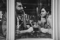 Grayscale Photo of Man and Woman Drinking Wine