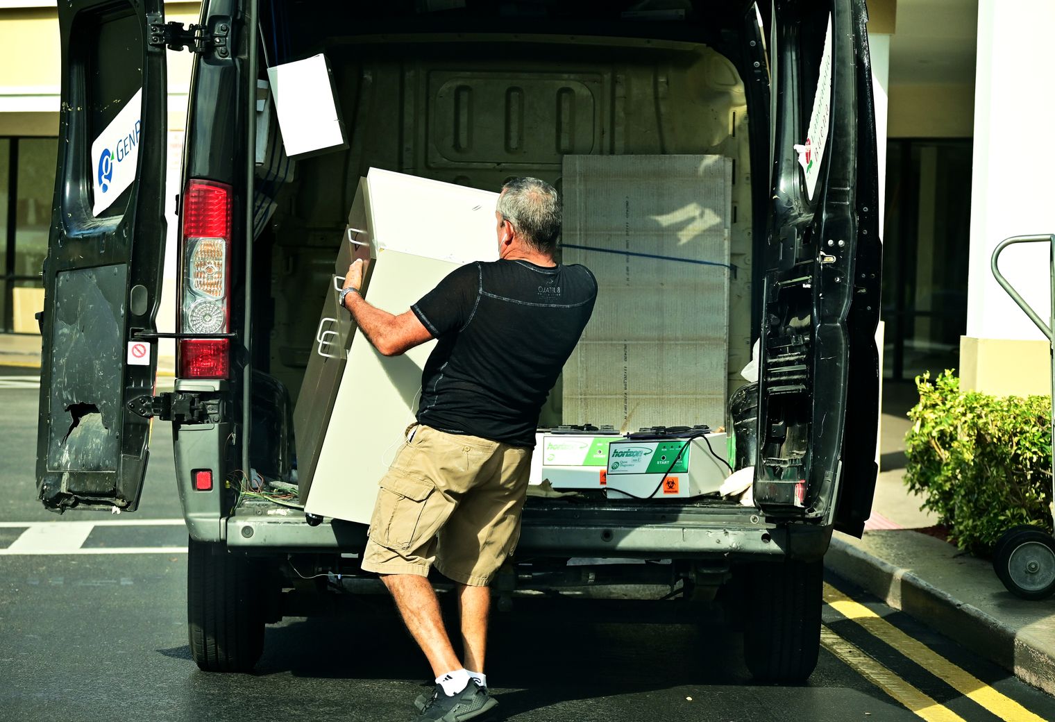 A mover loading furniture into a large open van