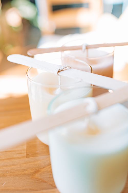 Free Brightly lit handmade candles in glass jars with wooden wicks on a wooden table. Stock Photo