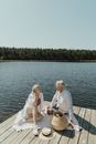 Man and Woman Sitting on Brown Wooden Dock