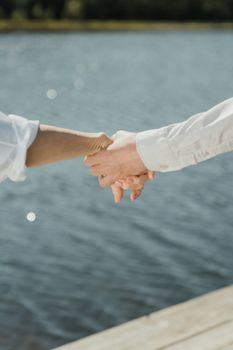 一对夫妇手牵着手，在宁静的湖边流露出爱意与亲密