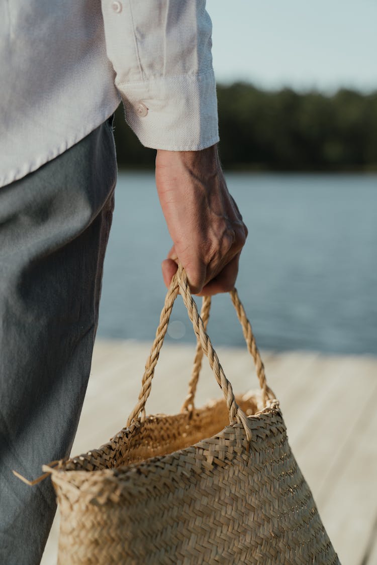 A Person Carrying A Straw Basket