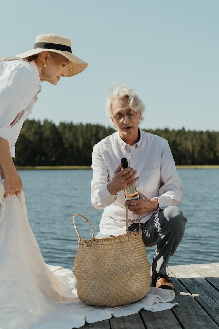 Elderly Couple Out For A Lakeside Picnic 

