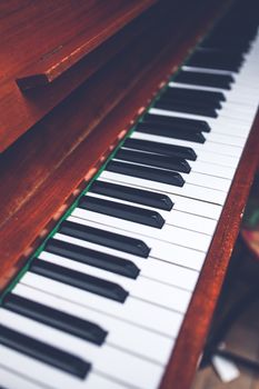 Close-up view of a wooden piano keyboard with black and white keys, showcasing classic design.
